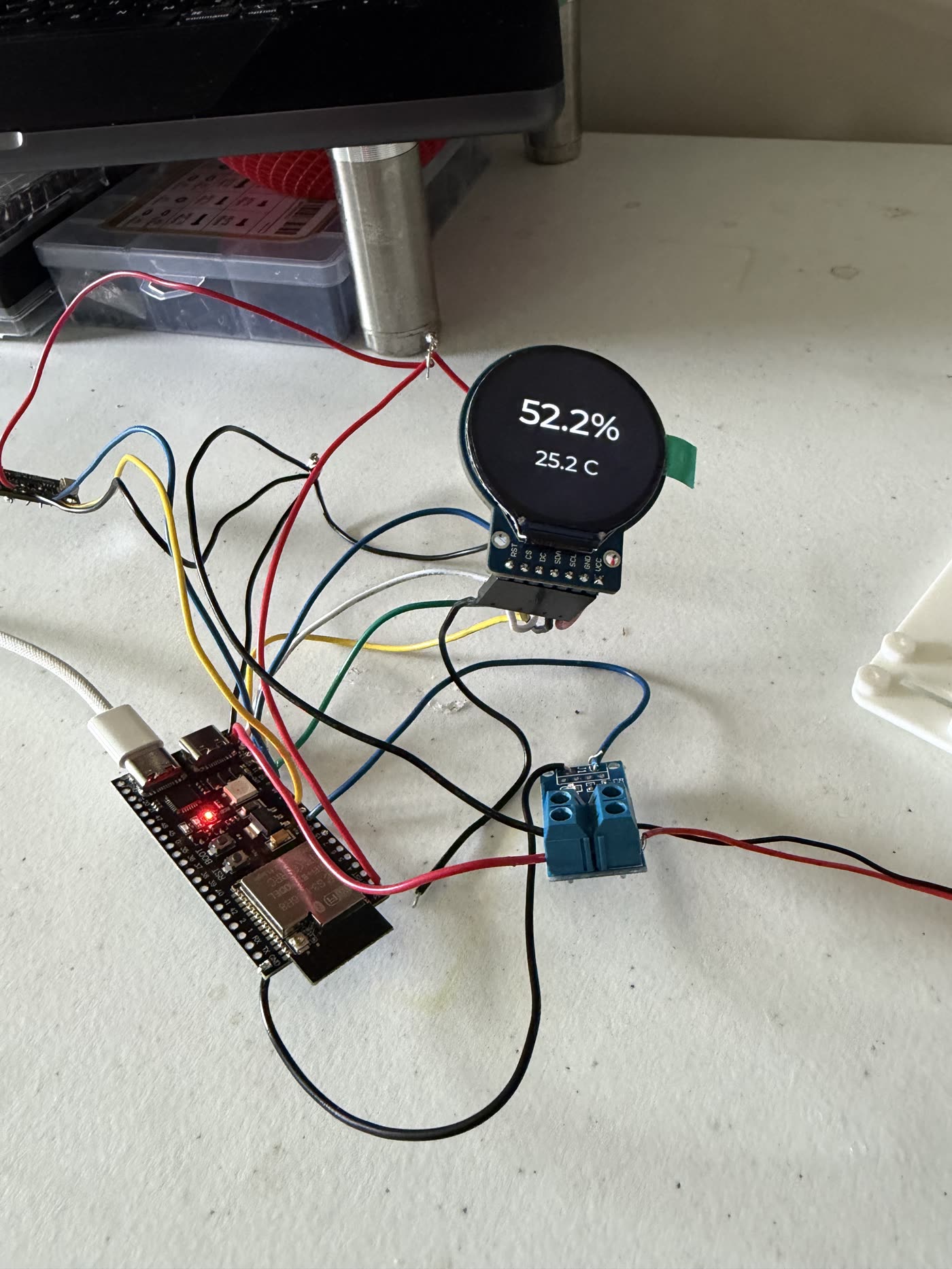 An ESP32 dev board wired with jumper wires to a round display and a temperature sensor, with the display reading 52.2 percent and 25.2 C